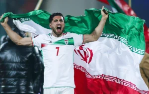 بازیکن تیم ملی فوتبال ایران در حال شادی با پرچم کشور